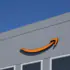 Amazon logo on the gray exterior of a building against a clear blue sky