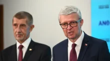 Karel Havlíček stojí vedle Andreje Babiše a mluví.