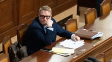 Aleš Juchelka sedí u stolu.