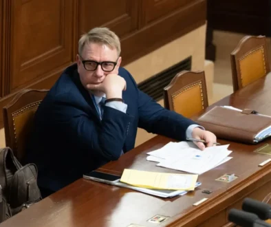 Aleš Juchelka sedí u stolu.