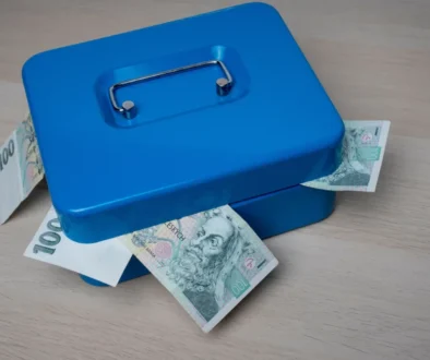 Modrá pokladnička s bankovkami v hodnotě 100 Kč