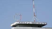 Záběr během jasného dne na střechu české veřejnoprávní televize s jejím logem