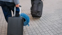 Lidé vezou kufry.