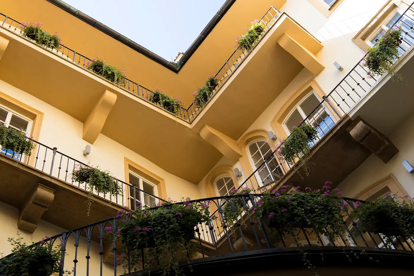Společné balkony ve vnitrobloku domu, který je nabarvený béžovou barvou